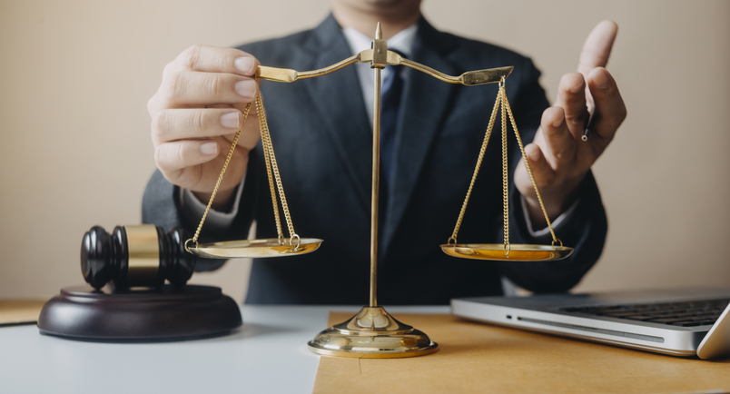 Justice and law concept.Male judge in a courtroom with the gavel, working with, computer and docking keyboard, eyeglasses, on table in morning light Oshawa Criminal Lawyer